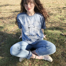Girl sitting in grass wearing blue Llama Alpaca Appalachia shirt